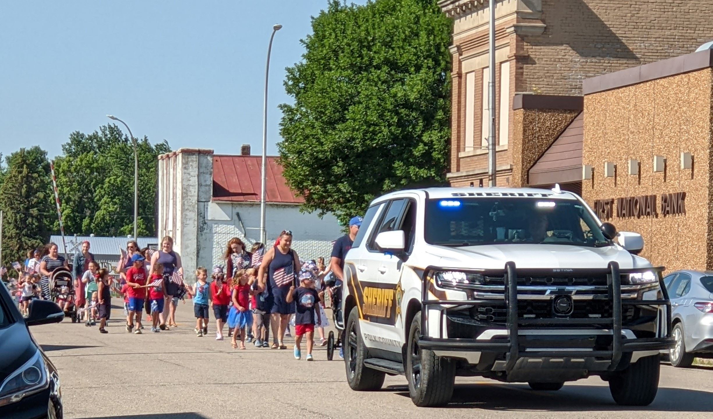 Sheriff Tadman and a parade follow behind a squad car