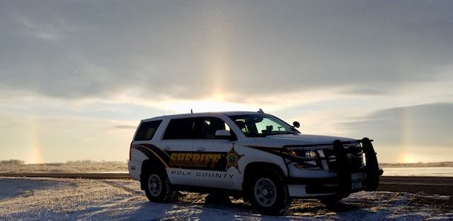 A sundog rises behind a squad car
