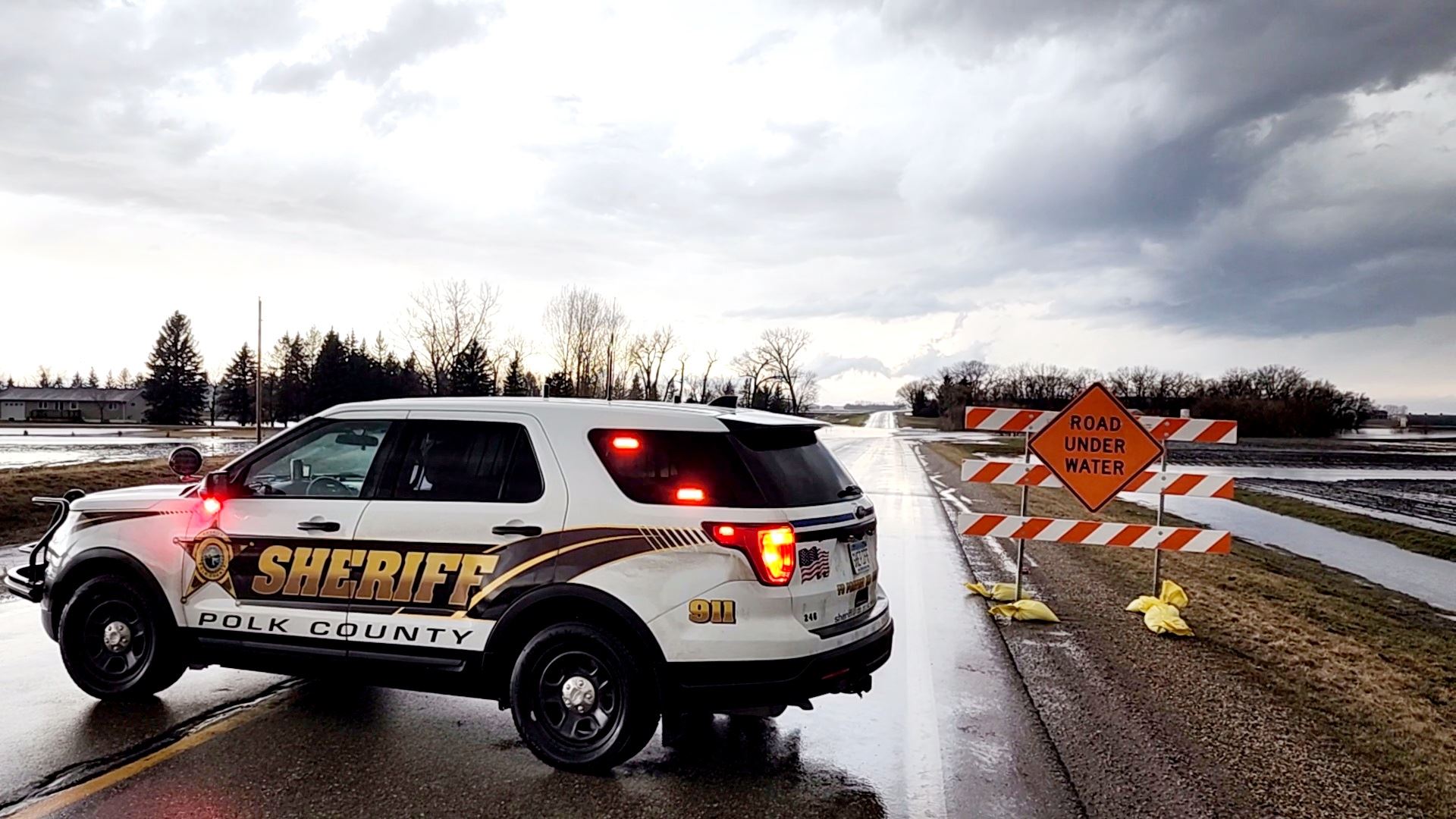 A Polk County vehicle blocks a flooded road.
