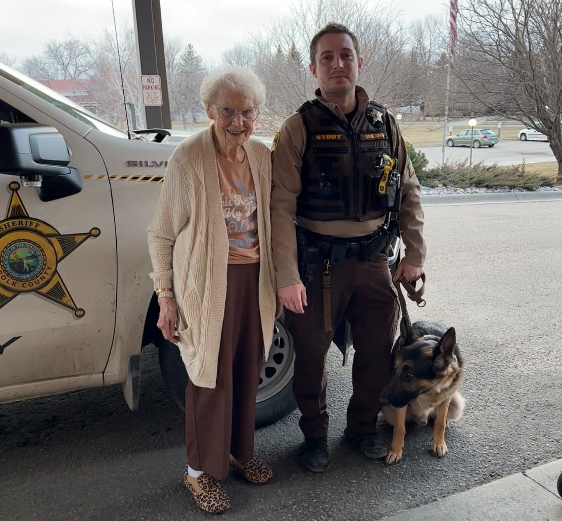A Polk County deputy and Rex pose with an area resident.