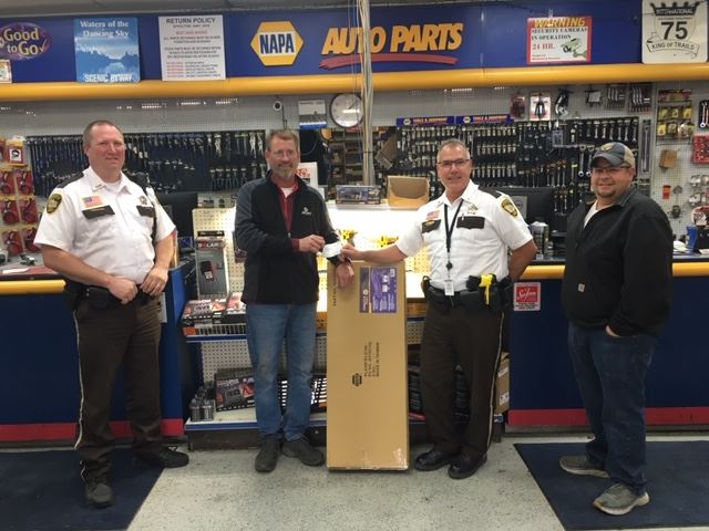 Polk County Sheriff Tadman and Chief Deputy Norland receive a donation from Napa Auto Parts.