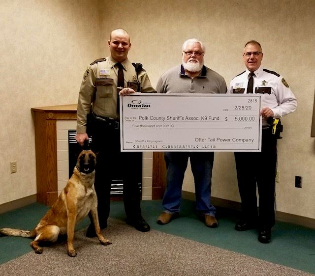 Polk County Sheriff Tadman receives a donation from Otter Tail Power Company.